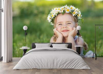 Little girl in nature with a wreath of flowers on her head. Wall mural