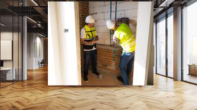 Architect and contractor working on building in construction site. Two Professional Architects Engineer Working  at house construction site Wall mural