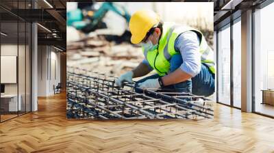 Asian construction worker on building site. fabricating steel reinforcement bar. wearing surgical face mask during coronavirus and flu outbreak Wall mural