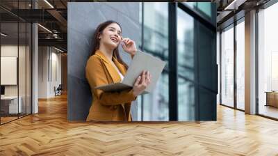 businesswoman - Successful business woman working with laptop computer standing near office building. City businesswoman working Wall mural