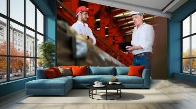 Caucasian business man and Factory engineer talking and discussion at Heavy Industry Manufacturing Factory. worker in safety hardhat at factory industrial facilities Wall mural