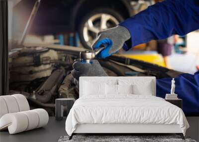 Close up mechanical hand with tools and spanner. Hispanic latin male mechanic repairs car in garage. Car maintenance and auto service garage concept Wall mural