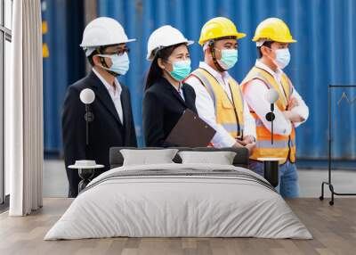 Group of professional team worker wearing protection face mask during coronavirus and flu outbreak and wearing safety hardhat helmet at container yard or cargo warehouse Wall mural