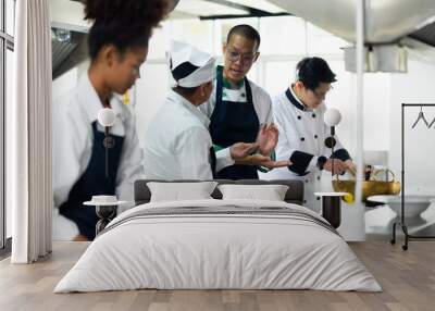 Group of student learning. Cooking class. culinary classroom. group of happy mature man and young woman multi - ethnic students are focusing on cooking lessons in a cooking school. Wall mural