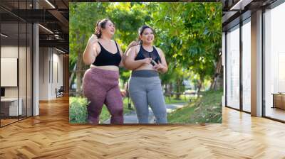 LGBTQ couple.Two smiling sporty young chubby overweight women in sportswear walking in park after workout. fitness sport club, body and health care. Outdoor Activity Wall mural