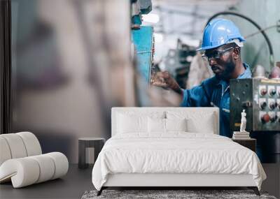 Male Engineer Working on laptop computer in Factory. black male engineer checking Quality control the condition of the machine. Service and maintenance of factory machinery Wall mural