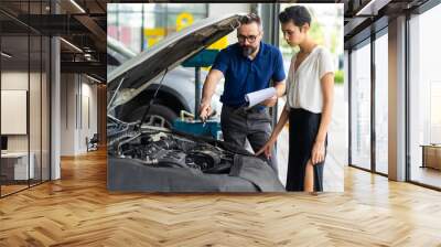 Mechanic man and woman customer check the car condition before delivery. automobile repair maintenance station garage. Wall mural