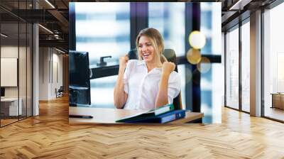 Portrait of smiling young business woman sitting on workplace Wall mural