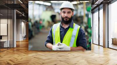 Portrait Professional mechanical engineering hispanic male in white safety hard hat helmet and look at camera at metal factory. Wall mural