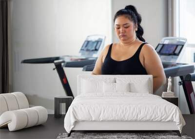 Portrait woman and fat belly. beautiful young chubby overweight woman wearing sporty fitness clothes doing exercise indoors at gym fitness sport club, body and health care Wall mural