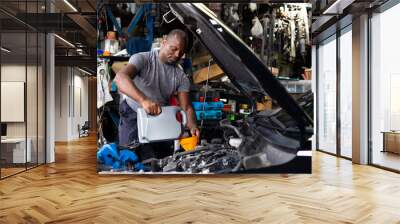 Pouring oil to car engine. Closue up male mechanic hand working  and service in Car Service station Wall mural