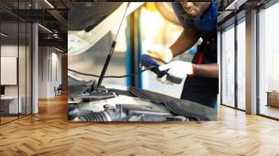 Professional car mechanic repair service and checking car engine by Diagnostics Software computer. Expertise mechanic working in automobile repair garage. Wall mural