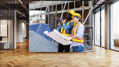 Professional Construction and  Engineer team Working on workplace. Professional black architect and construction worker working look at blueprint plan on site. Wall mural