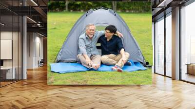 Senior Asian Father With Adult Son Enjoying Camping Holiday. senior mature father and smiling young adult Resting in the tent. Happy family time together. Wall mural