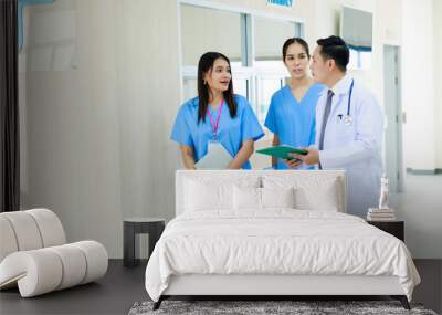 teamwork.  Asian male doctor talking with two asian female surgeon doctor and walking.  Hospital Healthcare medical and medicine concept. Wall mural