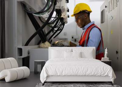 Technician engineering man working on laptop computer checking transformer in factory. business and industry concept Wall mural