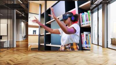 VR headset library. Young teen girl student training and learning with VR virtual teality headset in school library. Wall mural