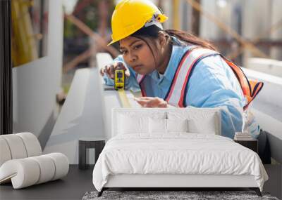 Yellow tape measure construction tools. Plus size female worker wearing safety hardhat inspec quality control at heavy Prefabricated concrete walls manufacturing factory Wall mural