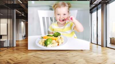 Child girl eating vegetables,healthy kid's nutrition. Wall mural