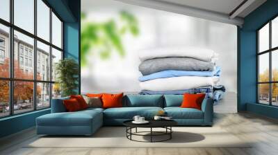 Cotton folded clothes on table indoors. Clean apparel stacked. Stack of clothing. Wall mural