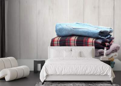 Stack of clothing on white table wooden plank background.Folded clothes pile empty copy space. Wall mural