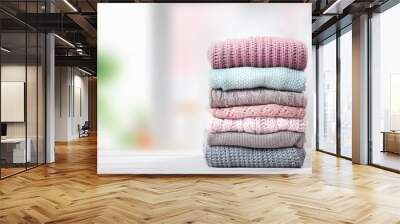 Stack of knitted textured clothing on table.Colorful winter clothes,warm apparel.Heap of knitwear. Wall mural