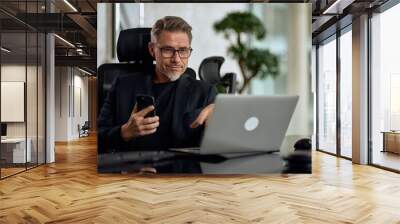 Business portrait - Businessman working with laptop computer and phone sitting in meeting room in modern office. Happy middle aged, mid adult, mature age man smiling. Wall mural