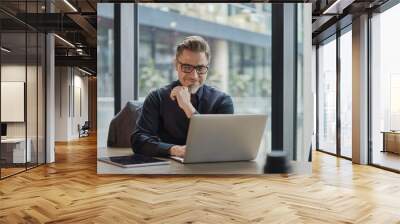 Businessman using laptop computer in office. Happy middle aged man, entrepreneur, small business owner working online. Wall mural