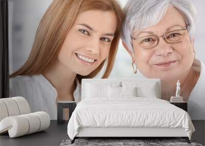 Closeup portrait of young woman and mother smiling Wall mural