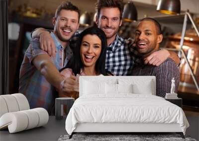 Group of happy friends clinking with beer in pub Wall mural