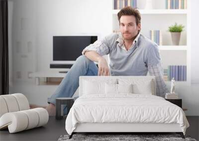 handsome man sitting on living room floor Wall mural