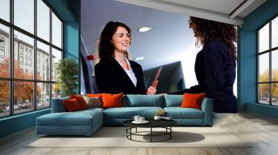 happy businesswomen shaking hands at office corridor Wall mural