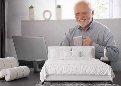 mature man with computer smiling Wall mural