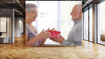 Senior female getting present from husband Wall mural