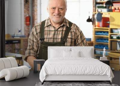 Senior happy handyman working at DIY workshop Wall mural