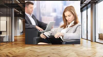 young businesswoman looking at organizer Wall mural