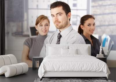 Young colleagues standing in office arms crossed Wall mural