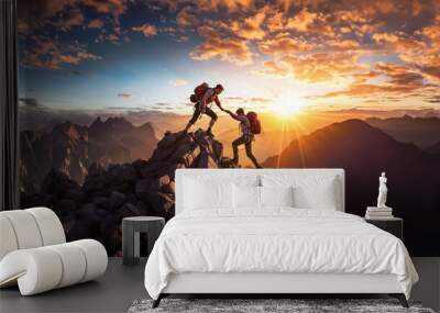 Two people climbing a mountain with backpacks on. One person helps another person. The sun is rising in the background. Wall mural