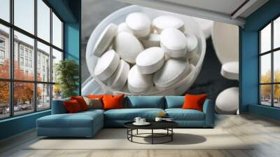 White medical supplement pills in the plastic spoon on dark background, macro image Wall mural