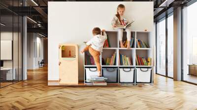 Brother and sister reading books in the children's room Wall mural