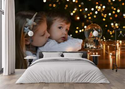 Children looking at a glass ball with a scene of the birth of Jesus Christ Wall mural