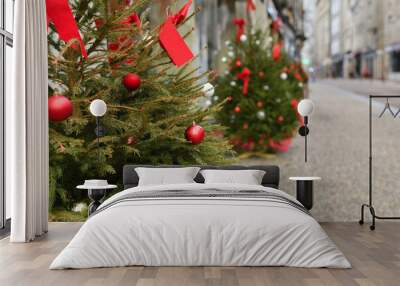 Decorated Christmas trees in front of shops in the city Wall mural