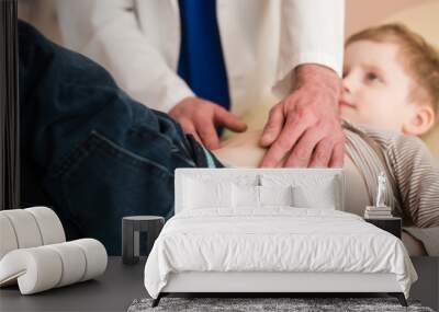 Hands of pediatrician on kid tummy close-up Wall mural