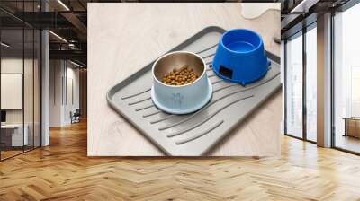 Plastic clean tray with two big bowls for animal pet dog full of granulated dry meal food and water at home floor Wall mural