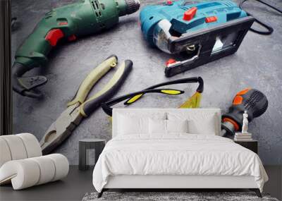 A set of tools on a rough gray surface, ready to work. Safety glasses in the foreground. Wall mural