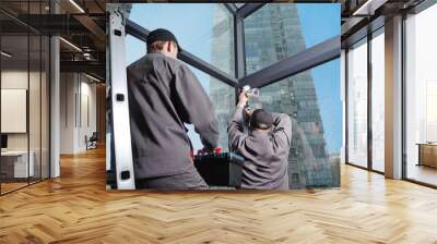 Installation of video surveillance, security system, security specialist at work. Interior, skyscraper in the background Wall mural