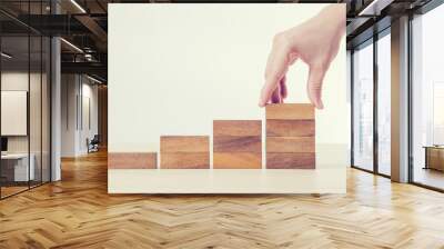 Close up female hand arranging wood block stacking as step stair. Business concept growth success process. retro filter. Wall mural