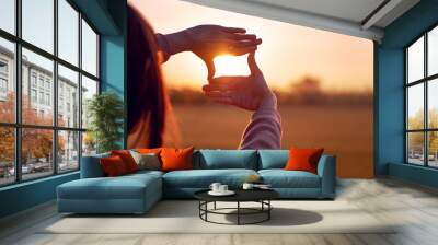 Future planning concept, Close up of woman hands making frame gesture with sunset, Female capturing the sunrise. Wall mural