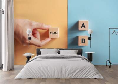 Hand choose wooden cube with the word PLAN A to PLAN B on blue and yellow background. Business concept. Wall mural