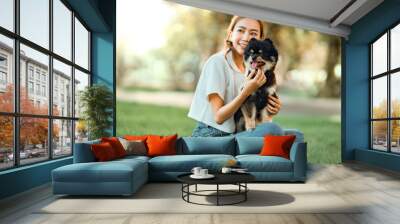 Happy asian woman playing with dog together in park outdoors, summer vacation. Wall mural